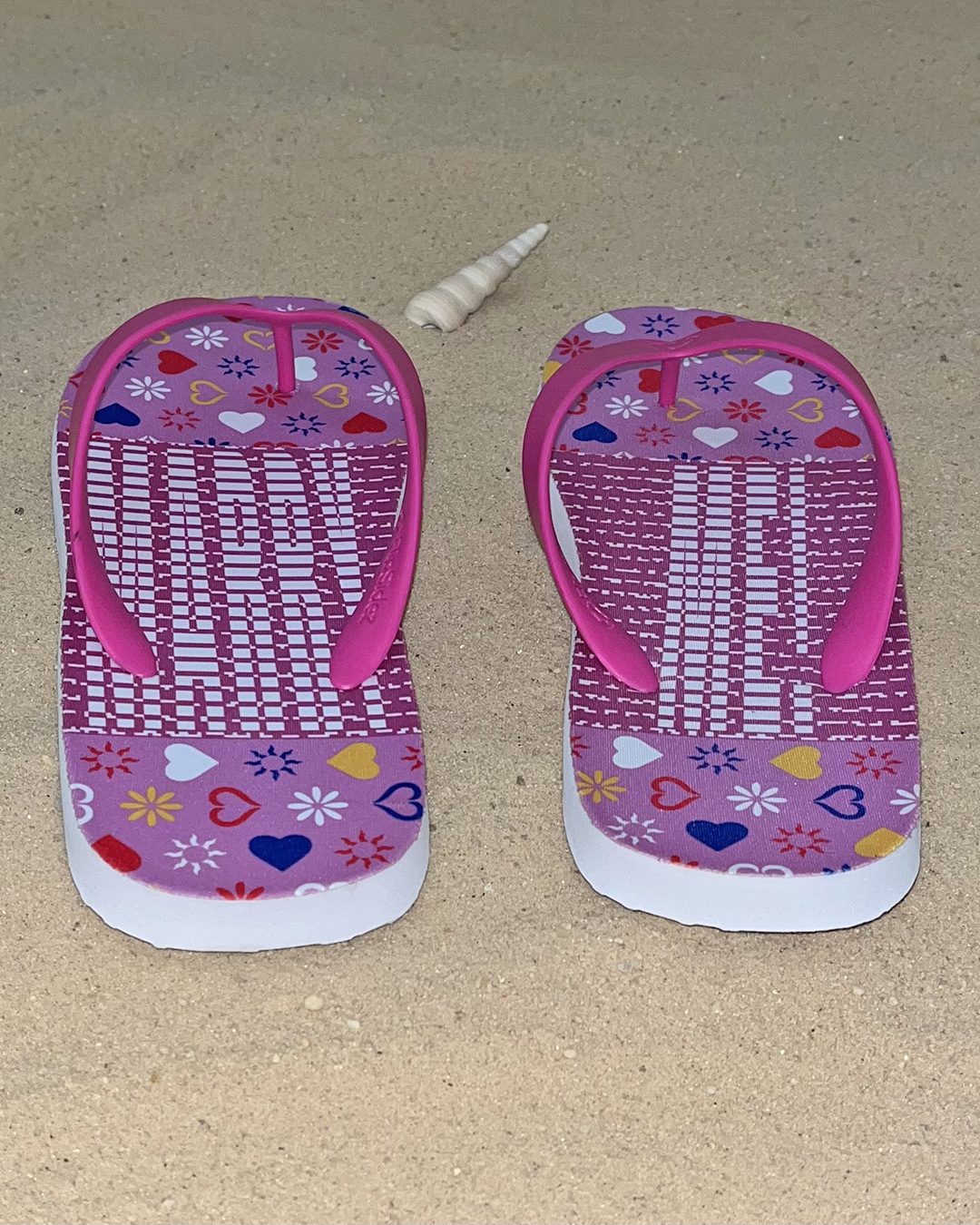 The pink flip flops seen from the heel, showing their hidden message